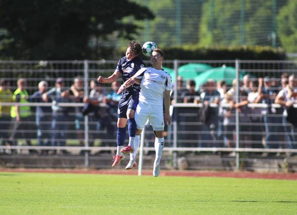 Fussball, Herren, Regionalliga Bayern, Saison 2026 2027, SV Wacker Burghausen - TSV 1860 München , flatbuy-Stadion an der Liebigstraße Lance Fiedler (TSV 1860 München) (li.) mit Alexander Gordok (SV Wacker Burghausen) (re.) im Zweikampf um den Ball, Kopfballduell