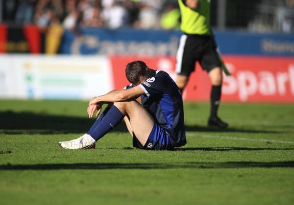 Fussball, Herren, Regionalliga Bayern, Saison 2026 2027, SV Wacker Burghausen - TSV 1860 München , flatbuy-Stadion an der Liebigstraße Emre Erdogan (TSV 1860 München) nach dem Schlusspfiff enttäuscht, niedergeschalgen auf dem Spielfeld sitzend