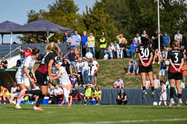 25.09.2026, Fußball, 1. HauptrunDFB-Pokal Frauen 2026 2027, SG 99 Andernach - SC Freiburg Emelie Hesselbach (8 SG 99 Andernach) schießt in den letzten Minuten noch einen Freistoß. Die Freiburger Mauer um Ilayda Acikgöz und Alina Axtmann springt hoch.
