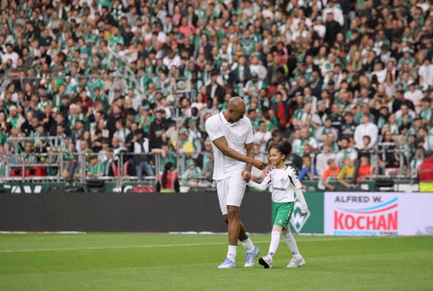 Foto : Naldo (Bremen , bürgerlich Ronaldo Aparecido Rodrigues ) bei der Teamvorstellung , mit einem der Ballmädchen Einlaufkinder - seiner Tochter Liz - an der Hand betritt er das Spielfeld ... und geniesst das Bad in der Menge Fussball Bundesliga Sonderspiel , am Sa. 26.09.2026 Jubiläumsspiel 100 Jahre Weserstadion Werder Bremen Legenden - Real Madrid Leyendas