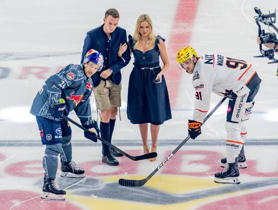 Wiesn-Playmate Valentina Ruckle fuehrt das Anbully aus zwischen Dominik Kahun (EHC Red Bull Muenchen, 21) und Austin Wagner (Loewen Frankfurt, 91) GER, EHC Red Bull Muenchen vs. Loewen Frankfurt Eishockey, DEL, Saison 2026 2027, 4. Spieltag, 27.09.2026. Foto: HMB Media Franz Feiner Copyright: HMBxMedia FranzxFeiner