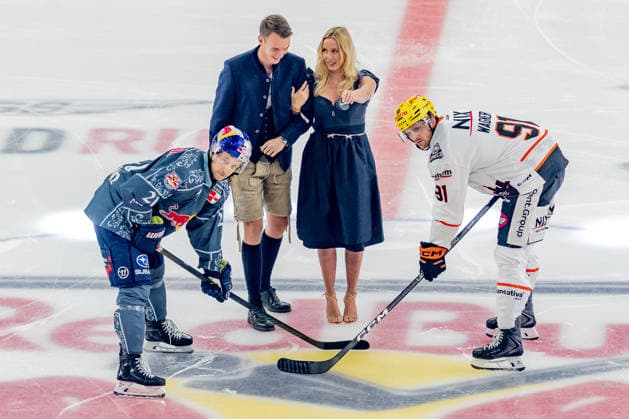 Wiesn-Playmate Valentina Ruckle fuehrt das Anbully aus zwischen Dominik Kahun (EHC Red Bull Muenchen, 21) und Austin Wagner (Loewen Frankfurt, 91) GER, EHC Red Bull Muenchen vs. Loewen Frankfurt Eishockey, DEL, Saison 2026 2027, 4. Spieltag, 27.09.2026. Foto: HMB Media Franz Feiner Copyright: HMBxMedia FranzxFeiner