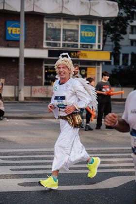 27.09.26, BMW Berlin Marathon 2026, Berlin A runner wearing an angel costume with wings and a halo runs along a city street during the BMW Berlin-Marathon in Berlin, Germany. Berlin Berlin BE Deutschland