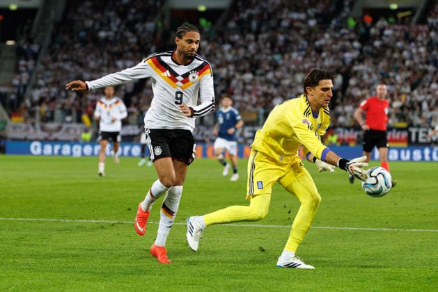 Kostas Tzolakis (12, Griechenland) vor Kevin Schade (9, Deutschland) beim Spiel zwischen Deutschland v Griechenland, Fussball, Herren, UEFA Nations League, 2026 2027, 2.Spieltag am 27.09.2026 in Augsburg, WWK Arena. Bayern Deutschland