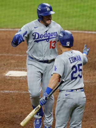 Los Angeles Dodgers Max Muncy (13) celebrates with Tommy Edman (25) after hitting a solo home run in the ninth inning against the Atlanta Braves in an MLB, Baseball Herren, USA National League Division Series playoff game at Truist Park in Atlanta, Georgia, on Wednesday, October 7, 2026. The Dodgers defeated the Braves 4-1 to win the series 3 games to 1 and advance to the Championship round.  ATL20261007723 MIKExZARRILLI