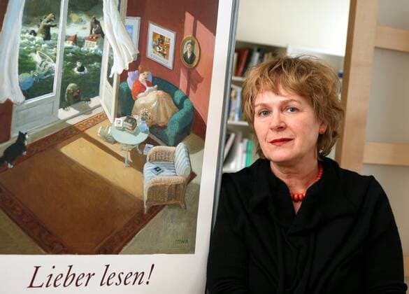 Verlegerin Antje Kunstmann (GER Verlag Antje Kunstmann GmbH) neben einem Bild mit dem Schriftzug - Lieber lesen! - in ihrem Büro in München
