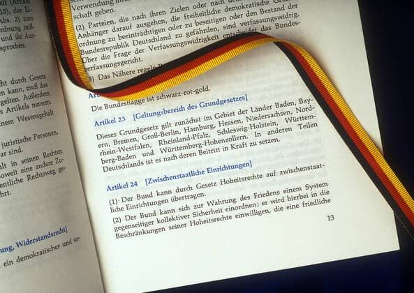 Grundgesetz der Bundesrepublik Deutschland mit Band in den Farben der Deutschlandfahne