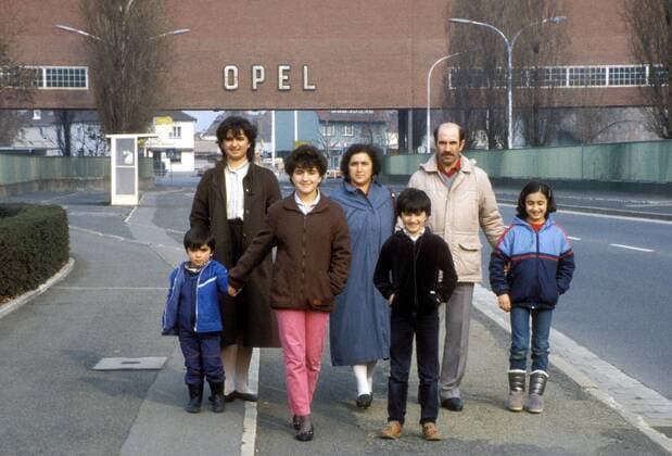 Türkische Gastarbeiterfamilie vor dem Tor der Opel-Werke in Rüsselsheim