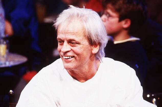 Klaus Kinski (Schauspieler) 10 85 brüg Mann TV Fernsehen Schauspiel Film Kino grauhaarig leger Shirt weiß sitzend Publikum Zuschauer Portrait quer lächelnd