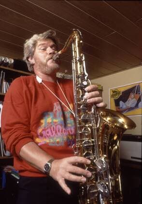 Peter Petrel 04 85 geue Mann Musik Schlager blond Bart Schnäuzer hoch halb stehend Instrument Saxophon spielend leger Pullover rot Homestory