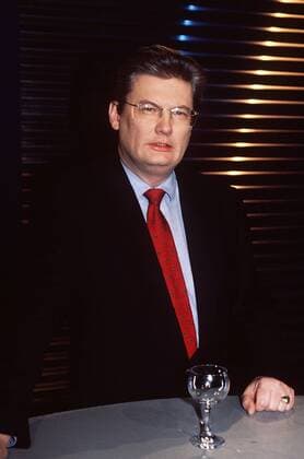 Sigmund Gottlieb (Journalist) 01 98 pu Mann Journalismus TV Fernsehen Moderation dunkelhaarig seriös Hemd Jackett Krawatte stehend Tisch Glas Studio Dekoration Kulisse halb hoch neutral Brille