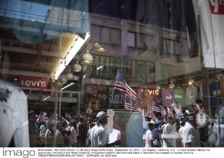 September 22, 2013 - Los Angeles, California, U.S. - A store window reflects the people who marched in the Million Voices for Immigration Reform rally that took place in downtown Los Angeles on Sunday morning. - ZUMAc200