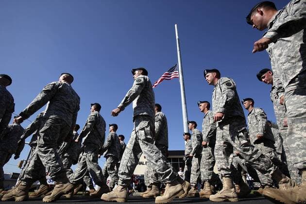 Nov. 11, 2009 - Killeen, Texas, U.S. - U.S. Army soldiers from Fort Hood Army Post walk past an American flag at half staff during the Veteran s Day Parade. Less than a week ago, a shooting rampage claimed the lives of 12 soldiers and one civilian. Fort Hood s commanding general is calling on the post to dedicate itself to the memories of those victims on this day. - ZUMAa27_