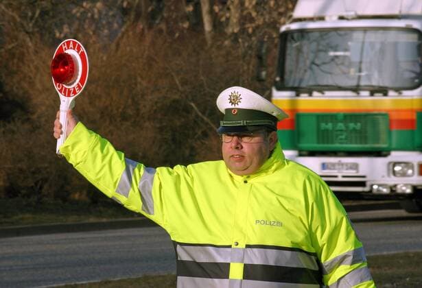 24.02.2006, Magdeburg, Sachsen-Anhalt, Deutschland - Verkehrspolizist haelt eine Haltekelle hoch. (QF, europäisch, Öffentlicher Dienst, Verkehrsleitgerät) 00S060224D707.JPG MODEL RELEASE: NO, PROPERTY RELEASE: NO MR:N