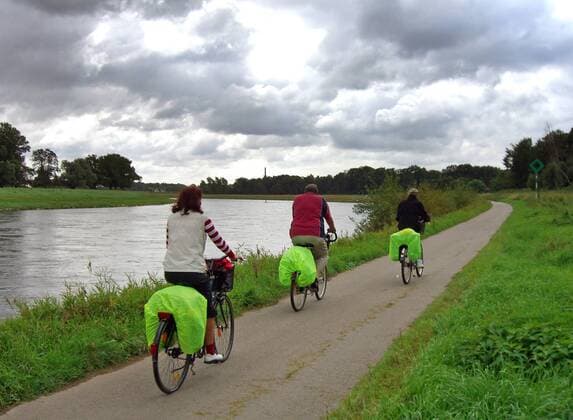 09.05.2006, Magdeburg, Sachsen-Anhalt, Deutschland - Fahrradfahrer fahren an der Elbe entlang. (QF, europäisch, Fahrräder, Räder, Körperbetätigung, Frühling, Rückansicht, Gewässer, bewölkt, düster, Aktivität, Zweiräder) 00S060509D716.JPG MODEL RELEASE: NO, PROPERTY RELEASE: NO MR:N