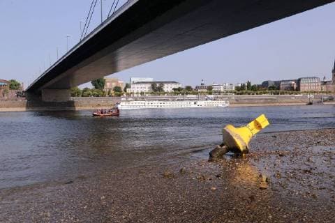News Bilder des Tages Der Rhein in Düsseldorf wird aufgrund der anhaltenden Trockenheit immer schmaler. Die Bunen am Ufer under Oberkasseler Brücke sind komplett zusehen. Der Weg zum Wasser führt die wenigen Badegäste über eine ausgetrocknete Schotterpiste. Heutiger Pegelstand 84 cm. Durch den Sog der Frachter zieht sich das Rheinwasser kurz zurück, um dann wieder zurückzulaufen.