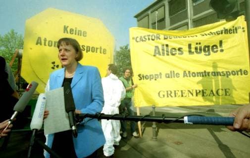 German Environment Minister Angela Merkel inspects a Greenpeace demonstration in front of the Bonn Ministry Wednesday, May 20, 1998. Demonstrators protest with artificial smoke and banners against nuclear transports which they believe are not safe and dangerous to the country. The banner reads: No nuclear transports! --- Bundesumweltministerin Angela Merkel besucht eine Greenpeace-Demonstration vor dem Bonner Ministerium am Mittwoch, den 20. Mai 1998. Demonstranten protestieren mit künstlichem Rauch und Bannern gegen Atomtransporte, die ihrer Meinung nach nicht sicher und gefährlich für das Land sind. Auf dem Banner steht: Keine Atomtransporte!