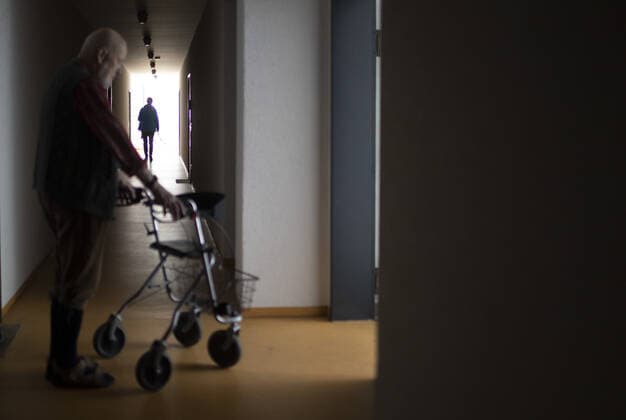 Thema: Mann mit Rollator in einem dunklen Flur. Heidelberg Deutschland
