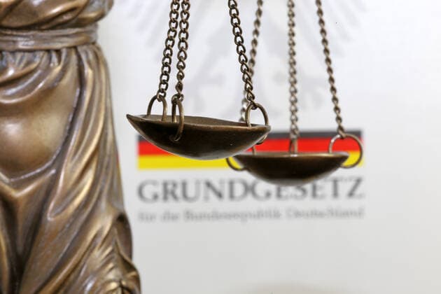 Close-up of a Justitia in front of a german basic law book