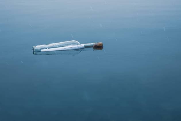 Flasche mit Flaschenpost im Winter am See, verschneit Flaschenpost