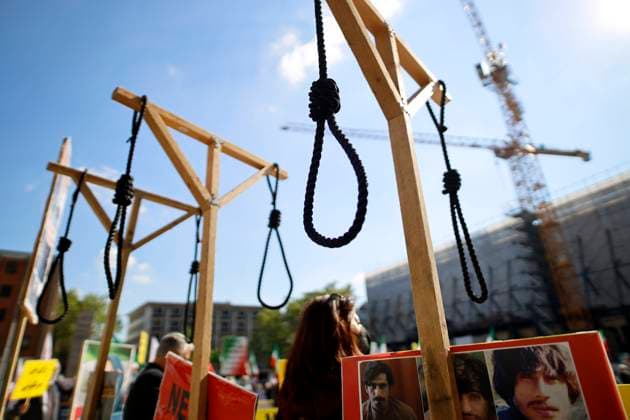 Eine Demonstration von Gegnern des Mullah-Regimes in Teheran fordert Solidarität mit der Opposition im Iran, die Abschaffung der Todesstrafe und einen Umsturz. Sie halten iranische Flaggen und haben einige Galgen aus Holz aufgebaut, welche die martiallschen Hinrichtungsmethoden im Iran veranschaulichen sollen. Die Demo wurde mit Corona-Auflagen zugelassen auf dem Roncalliplatz direkt am Kölner Dom. Köln, 29.05.2021
