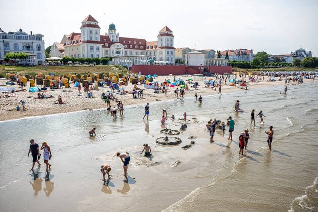 Bilder des Jahres 2021, News 07 Juli News Bilder des Tages Urlaub an der Ostsee. Im Ostseebad Binz auf der Insel Rügen sind die Touristen eingekehrt und genießen bei herrlichem Sonnenschein ihren wohlverdienten Urlaub. Blick auf das Kurhaus von der Seebrücke aus. Im Vordergrund spielen Kinder in der Ostsee und bauen Sandburgen. GER, Insel Rügen, Rügen, Ostseebad Binz, Binz, Vorpommern, Mecklenburg-Vorpommern, Urlaub, Reise, Tourismus