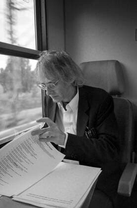 Timm Ulrichs im Zug von Berlin nach Magdeburg und korrigiert Fahnen für den Katalog Der detektorische Blick (NGBK), 19.9.1997. Auf dem Weg zu einer Arbeitsbesprechung wegen seines Entwurfs für die Erdachse auf dem Bahnhofsvorplatz in Magdeburg, die 1999 eingeweiht wurde. Die Zugfahrt nutzte Ulrichs zur Korrektur von Druckfahnen für seinen Katalog bei der NGBK Der detektorische Blick .