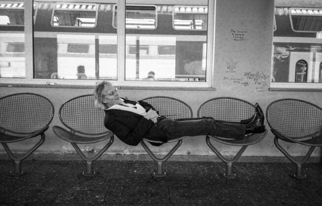 Timm Ulrichs demonstriert die Unbequemlichkeit der Ruhezone im Magdeburger HBF, 19.9.1997