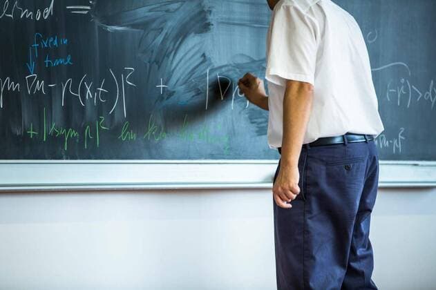 teacher teaching mathematics while pointing at blackboard in classroom model released, Symbolfoto, 13.10.2020, Copyright: xLightpoetx Panthermedia27207519