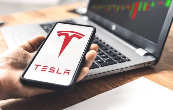 Tesla Auto Elektroauto Logo auf einem Smartphone, Handel an der Aktien Börse mit Anteilen der Tesla Aktie von Geschäftsführer Elon Musk, Online Trading mit Aktienanteilen xFOTOMONTAGEx