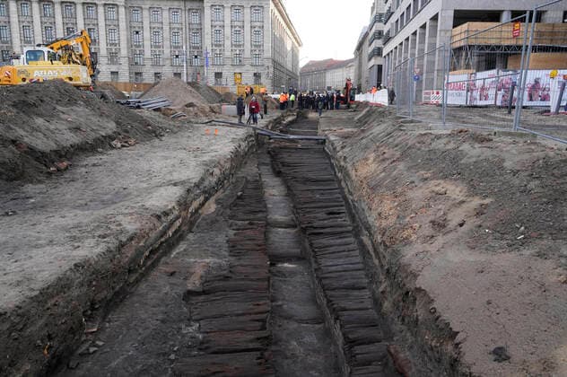 Bilder des Jahres 2022, News 01 Januar News Themen der Woche KW03 Etwa 2,50 m unter der Stralauer Straße haben die Archäologen des Landesdenkmalamtes Berlin überraschend einen mittelalterlichen Bohlendamm entdeckt. Er stammt aus der Gründungszeit Berlins im 13. Jahrhundert und ist damit eine der ältesten Straßen Berlins. Angelegt wurde der ca. 6 m breite Damm aus Eichen-, Kiefer- und Birkenstämmen. Die aufwändige hölzerne Befestigung der Straße ermöglichte hier nahe der Spree eine sichere Passage vom Mühlendamm in Richtung Stralauer Tor über den in Flussnähe sehr nassen Untergrund. Berlin, 19.01.2022