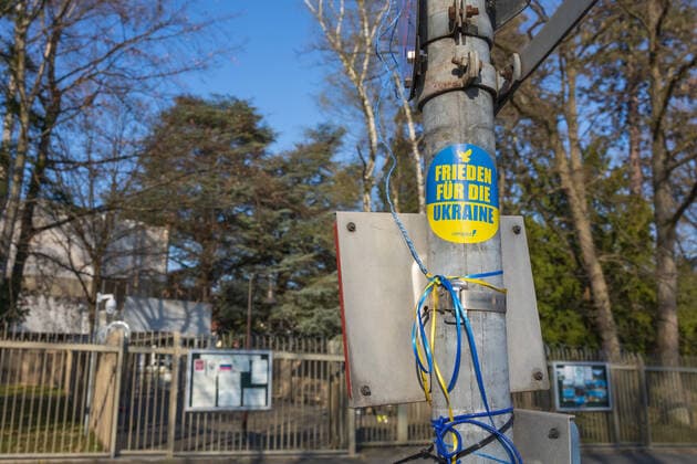 Ein Aufkleber mit der Aufschrift Frieden für die Ukraine an einem Schildermast gegenüber des Konsulates - Das Generalkonsulat der Russischen Föderation in Bonn war Standort der Botschaft der UdSSR, sowie bis zum Umzug der Bundesregierung 1999 die Botschaft der Russischen Föderation. Das Konsulat ist Ziel vieler Demonstrationen und Mahnwachen aus Anlass des Angriffskrieges in der Ukraine. Bonn Schweinheim NRW Deutschland