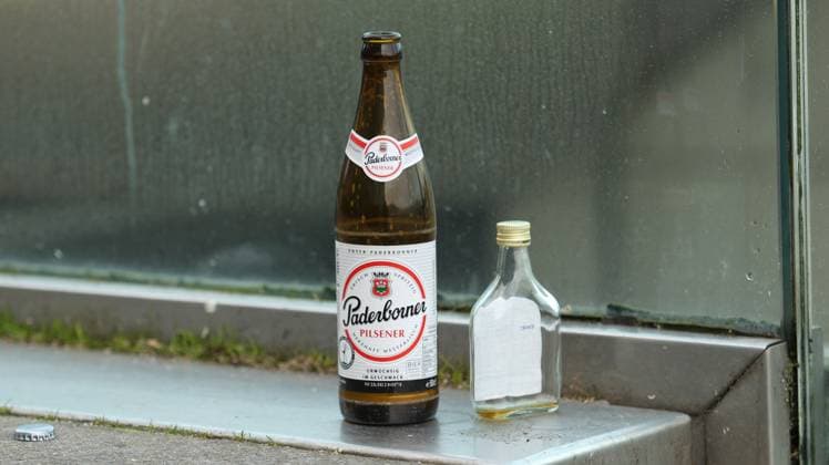 Eine leere Bierflasche der Marke Paderborner sowie leere Spirituosenflasche stehen auf einer Treppe in der Hamburger Altstadt. Symbolbild Alkoholsucht. Altstadt Hamburg