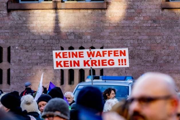 Schild: Keine Waffen Kein Krieg - Aktionswochenende öStoppt das Töten für Waffenstillstand und Verhandlungen!˜ von Deutsche Friedensgesellschaft Vereinigte KriegsdienstgegnerInnen auf dem Alter Markt in Köln 25.02.2023 Köln Altstadt NRW Deutschland