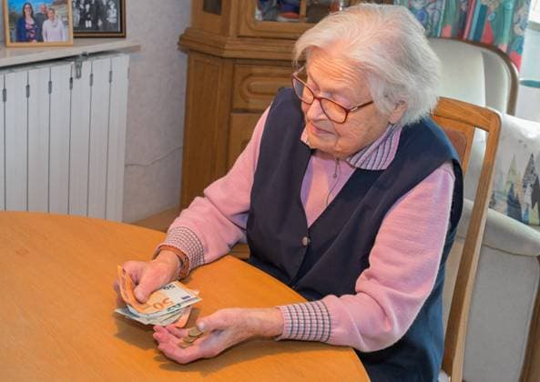 Alte Frau zählt Geld - model released