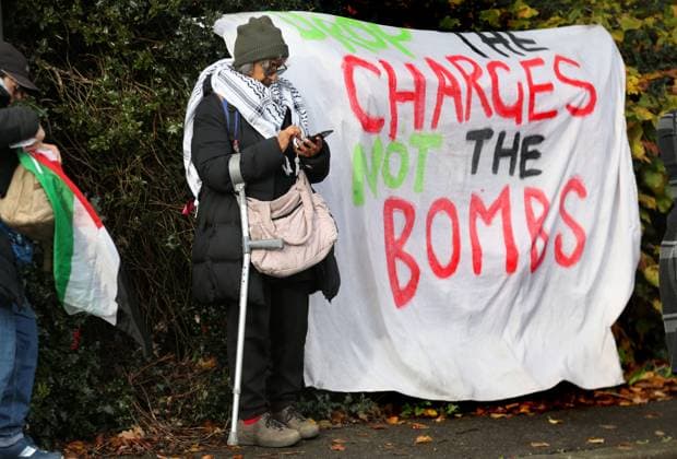 November 13, 2023, London, United Kingdom: Supporters pass the time outside Snaresbrook Crown Court standing next to a sign saying ˜Drop the Charges, Not the Bombs™. Palestinian Actionists known as ˜The Elbit Eight™ are facing conspiracy charges to commit criminal damage, burglary and some of them, blackmail, against Israeli arms company Elbit systems. The charges go back to 2020. Six weeks have been set aside at court. Palestine Action believe that Elbit™s businesses in the UK manufacture drones that are being used in Gaza and elsewhere against the Palestinian people. Their direct actions against Elbit Systems in the UK have already seen two of their 10 sites closed down. London United Kingdom - ZUMAs197 20231113_aaa_s197_438 Copyright: xMartinxPopex