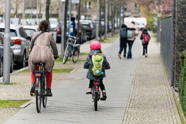 2024-03-21,Berlin,eine Frau und Kind sind jeweils mit einen Fahrrad auf dem Gehweg unterwegs