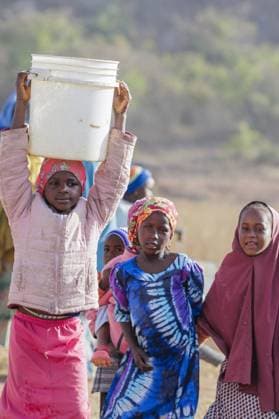 Maedchen traegt einen schweren Wassereimer auf dem Kopf, Maraban Dare, 07.02.2024. Maraban Dare Nigeria Copyright: xUtexGrabowskyxphotothek.dex