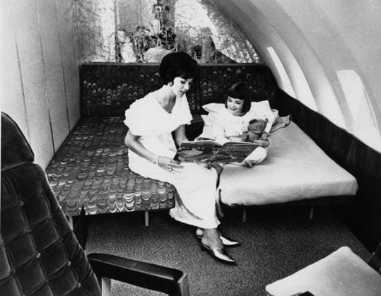 RECORD DATE NOT STATED JUMBO JET BEDTIME STORY Even on board a Boeing 747 Jumbo Jet , this young mother takes time to don her gold slippers and read a bedtime story (Winnie the Pooh, what else?) to her young daughter. Date: 1960s  Copyright: Copyrightx(c)Geminix2023.xCredit:xGemini 10185661
