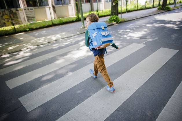 Symbolfoto zum Thema Schulkind im Strassenverkehr. Ein sechsjaehriger Junge laeuft mit seinem Schulranzen auf dem Ruecken ueber den Zebrastreifen eines Fussgaengerueberweges vor einer Grundschule. Berlin, 08.05.2024. Berlin Deutschland Copyright: xThomasxTrutschelxphotothek.dex
