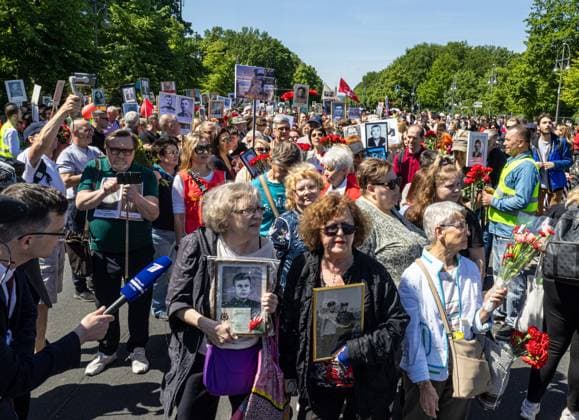Russen feiern mit Transparenten und Fotos verstorbener Soldaten der Tag der Befreiung, 8. 9. Mai, Demo, Berlin, Straße des 17. Juni, Sowjetisches Ehrenmal im Tiergarten; Russen feiern der Tag der Befreiung, 8. 9. Mai, Demo,
