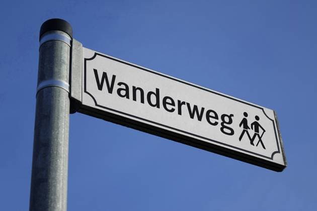 Schild mit Wanderweg und Piktogramm Schild mit Wanderweg und Piktogramm, 13.05.2024, Borkwalde, Brandenburg, Auf einem Schild befindet sich der Schriftzug Wanderweg mit einem Piktogramm.