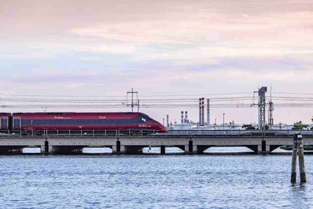 High-speed train operated by the private Italian railway company Italo. Ponte della Libertà, the bridge connecting Venice with the mainland. Venice, Venezia, Italy, Europe