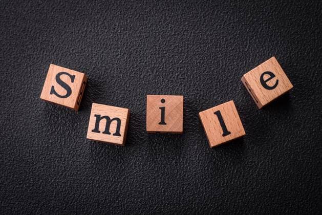 A concept consisting of the inscription of the word smile, with round emoticons on a dark concrete background A concept consisting of the inscription of the word smile, with round emoticons on a dark concrete background. Can be used as a background Copyright: xZoonar.com TetianaxChernykovax 21704989