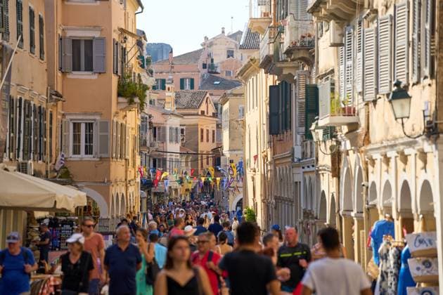 Menschenmengen in der Altstadt von Korfu, die lebendige Atmosphäre eines touristischen Hotspots einfangend, typisch für den Massentourismus in beliebten Reisezielen