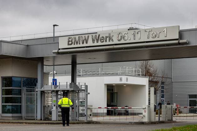 Automobilindustrie Eingangstor 1 des BMW Werks in Regensburg. Ein Mitarbeiter in gelber Warnweste betritt das Werksgelände durch ein Drehkreuz. Das moderne Gebäude zeigt das Firmenschild BMW Werk 06.11 Tor 1 auf einem grauen Hintergrund. Regensburg Burgweinting - Harting Bayern Deutschland