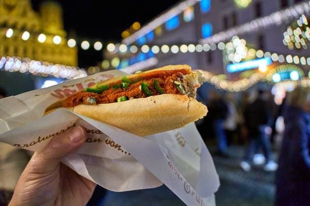 Augsburg, Bayern, Deutschland - 5 Dezember 2024: Vegane Bosna, bzw. Bratwurst in einer Semmel auf dem Augsburger Christkindlesmarkt, Symbol für Fleischersatz, pflanzliche Alternative, Preise und Essen auf dem Weihnachtsmarkt.