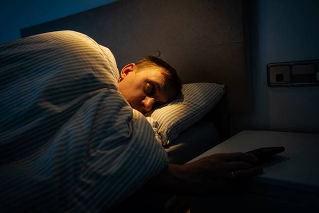 Mann liegt im Bett und schaut auf den Telefonbildschirm Mann liegt im Bett und schaut auf den Telefonbildschirm ,model released, Symbolfoto Copyright: xZoonar.com TatianaxGoskovax 22840697 ,model released, Symbolfoto ,property released
