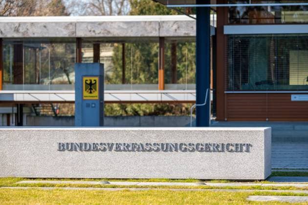 Der massive Steinblock mit der Aufschrift Bundesverfassungsgericht vor dem Gebäude bzw. Gericht in Karlsruhe, neben Bundesadler der Bundesrepublik Deutschland als Wappen.