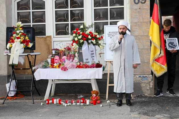 Bilder des Jahres 2025, News 03 März News Themen der Woche KW13 News Bilder des Tages Gedenkfeier 1 Jahr nach dem Brandanschlag auf das Mietshaus, wo die junge tuerkische Familie Zhilova ums Leben kam 25.03.2025, Solingen, Gruenewalder Strasse, Gedenkfeier 1 Jahr nach dem Brandanschlag wo eine 4 Koepfige Familie Zhilova ums leben kam im Bild: Gedenkstunde, ein Jahr nach dem Brandanschlag auf der Gruenewalder Strasse mit der türkischen-islamischen Gemeinde Ditib vor dem Haus stehen Mahnwachen mit den Namen und Bildern der ums Leben gekommenen Familie Zhilova und ein Tisch mit Blumen, Grablampen und Stofftieren, der Imam der türkisch islamischen Gemeinde Ditib betet Der Einzeltaeter wurde schnell gefasst, die Gerichtsverhandlungen laufen, es deutet alles auf Akt der Fremdenfeindlichkeit Fremdenhass hin.